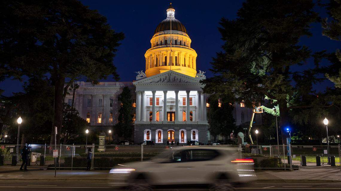 The California Capitol is tinted with an amber glow on Tuesday night, Jan. 19, 2021, as part of a nationwide remembrance of lives lost to COVID-19.
