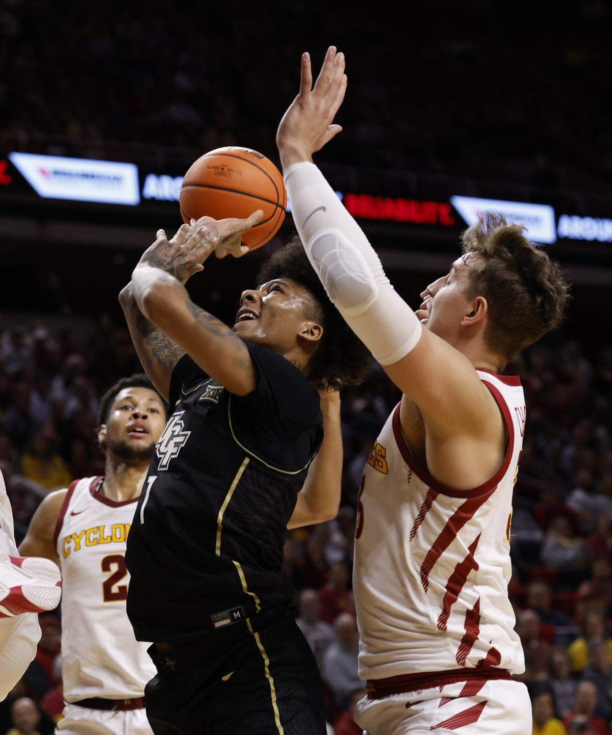Mikey Williams of the UCF Knights takes a shot as Iowa State Cyclones players defend him in the second half of play at Hilton Coliseum on Jan. 21, 2025, in Ames, Iowa.