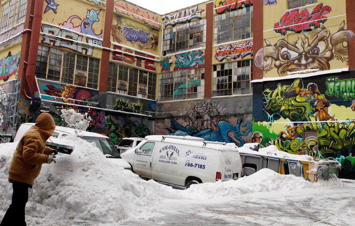 A man shovels snow in 2011 to clear a driveway near 5pointz, a graffiti art gallery in the Queens borough of New York. A judge awarded $6.7 million to two dozen graffiti artists whose spray paintings at the once-famous site that attracted thousands of spectators were destroyed to make room for high-rise luxury residences.