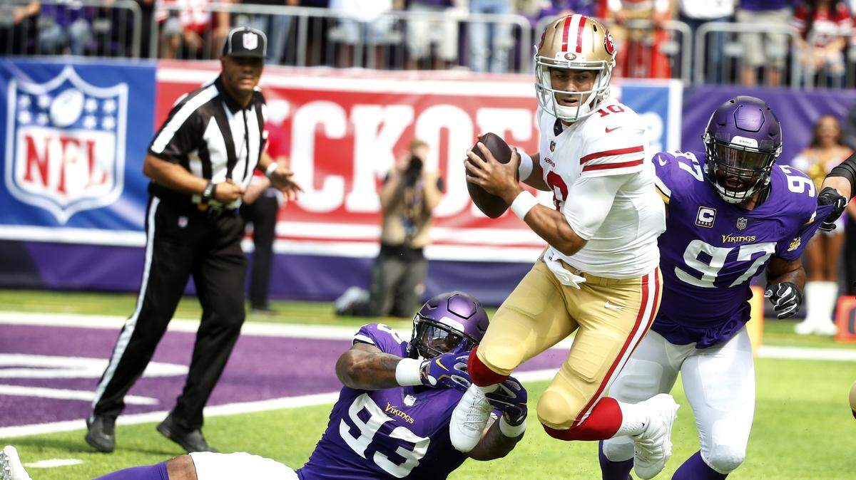 49ers quarterback Jimmy Garoppolo tries to escape Minnesota Vikings defenders in the 2018 season opener in Minneapolis. The teams will meet in the second round of the NFL playoffs Saturday at Levi’s Stadium.