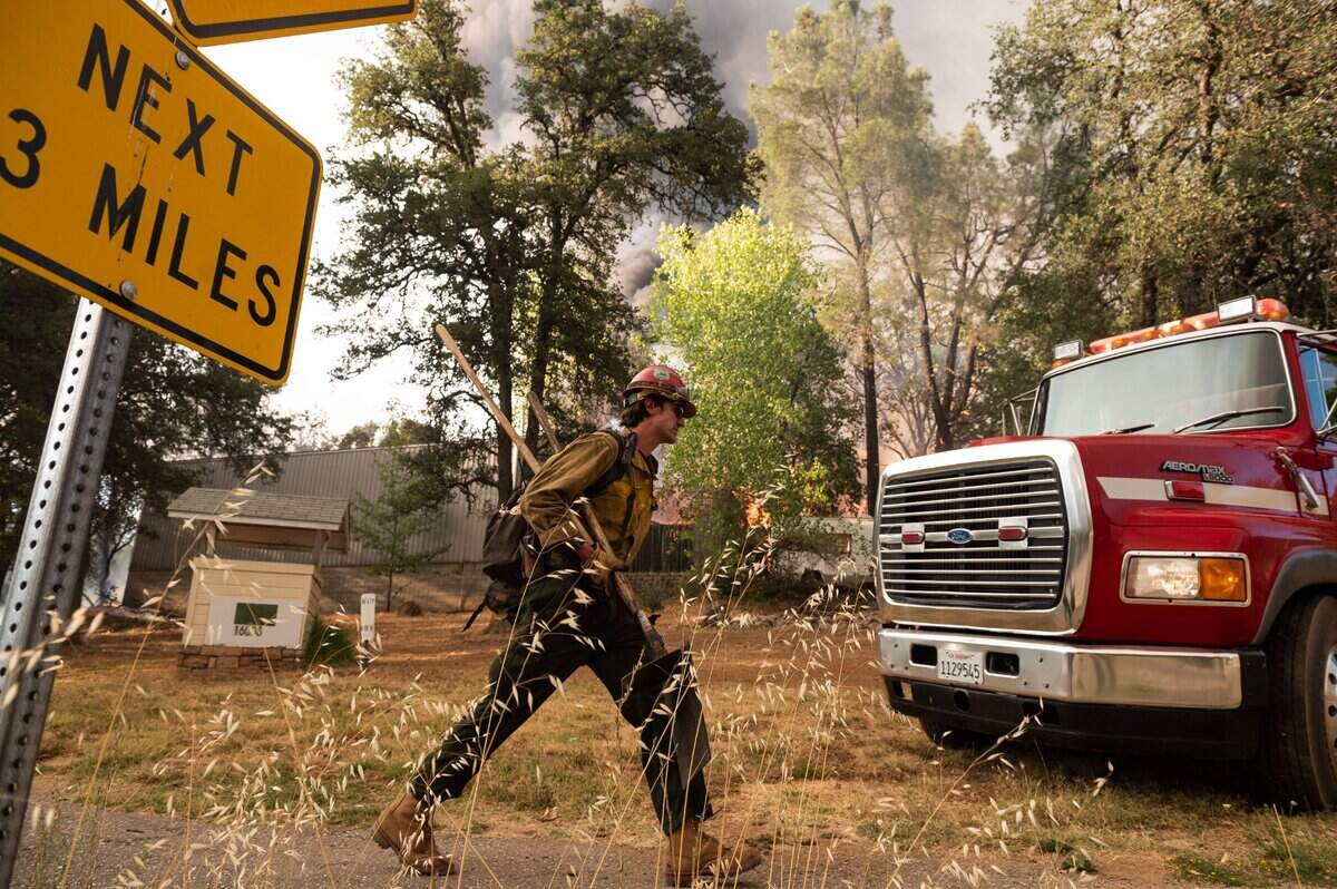 Personnel with the Tahoe Hotshots Region 5, U. S. Forest Service, try to save property off Mount Olive Road as the River Fire burns Wednesday, Aug. 4, 2021, in Nevada County.