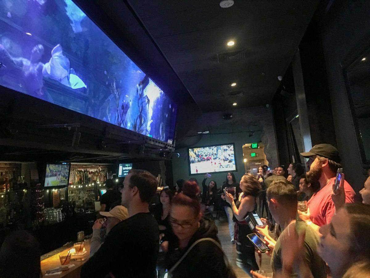 People watch the “mermaids” swim at Dive Bar on K Street in downtown Sacramento in June 2018.