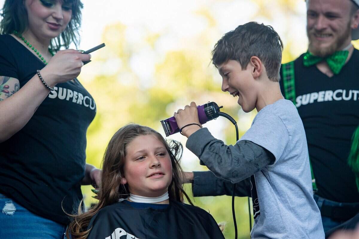 Alex de Veer White, 12, shaves the hair of his friend Nick Nelson, 12, during the St. Baldricks event. Nelson has been growing his hair out during the COVID-19 pandemic.