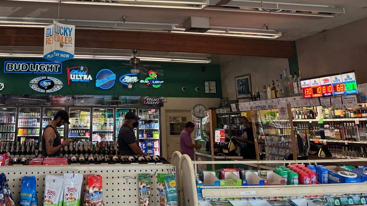 People line up at Lichine’s Liquor & Deli in Sacramento to play the Mega Millions lottery on Monday. Lichine’s is considered the “luckiest” store in the city.
