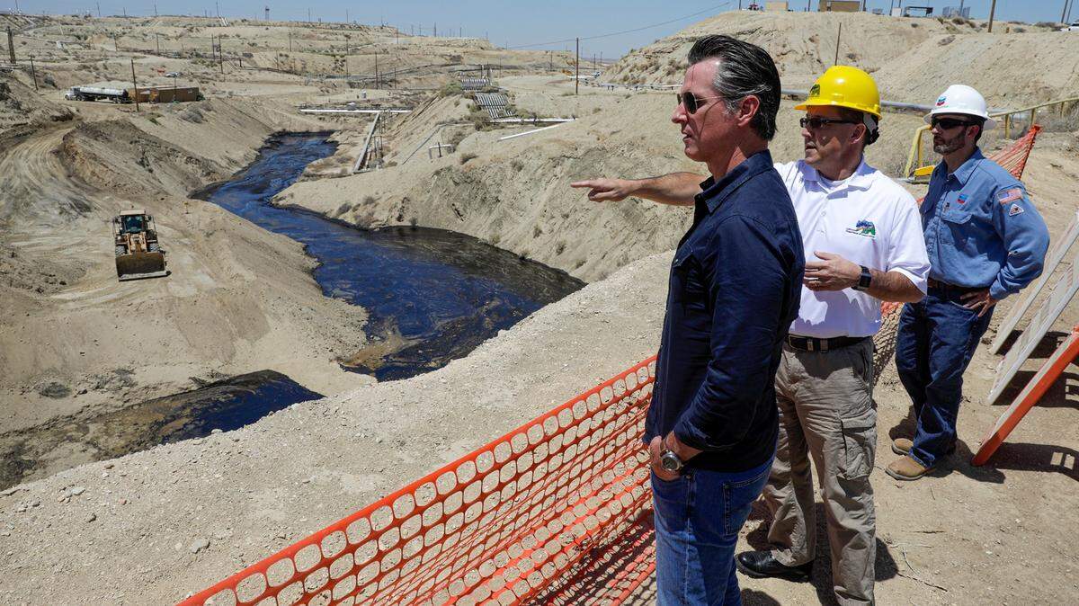 In this July 24, 2019, file photo, Gov. Gavin Newsom, left, is briefed by Jason Marshall, of the California Department of Conservation, Division of Oil and Gas, center; Billy Lacobie, of Chevron, while touring the Chevron oil field in McKittrick, Calif. Newsom says he is encouraged by Chevron’s efforts to clean up what has turned into the state’s largest oil spill in decades. California Gov. Newsom moved Wednesday, Sept. 23, 2020 to end issuing new hydraulic fracturing permits by 2024, a delay criticized by many environmental groups but characterized as legally and politically realistic by another.