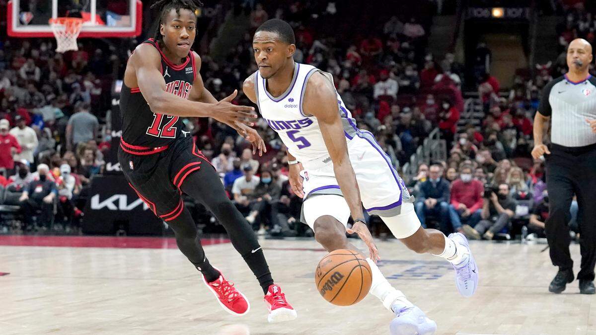 Sacramento Kings’ De’Aaron Fox, right, drives on Chicago Bulls’ Ayo Dosunmu during the first half of an NBA basketball game Wednesday, Feb. 16, 2022, in Chicago. (AP Photo/Charles Rex Arbogast)