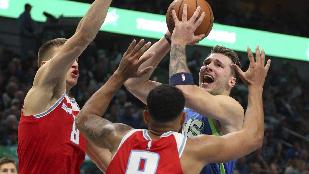 Dallas’ Luka Doncic drives into Kings defenders during their game Sunday night.