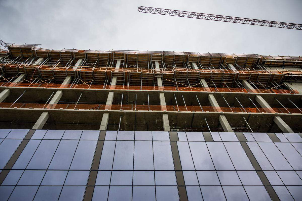 Glass windows manufactured by Sacramento-based Bagatelos Architectural Glass Systems cover part of the exterior of the first two Aggie Square buildings on Thursday, the day of a “topping off” ceremony to mark the completion of the framework of the structures. The buildings are expected to open in 2025.