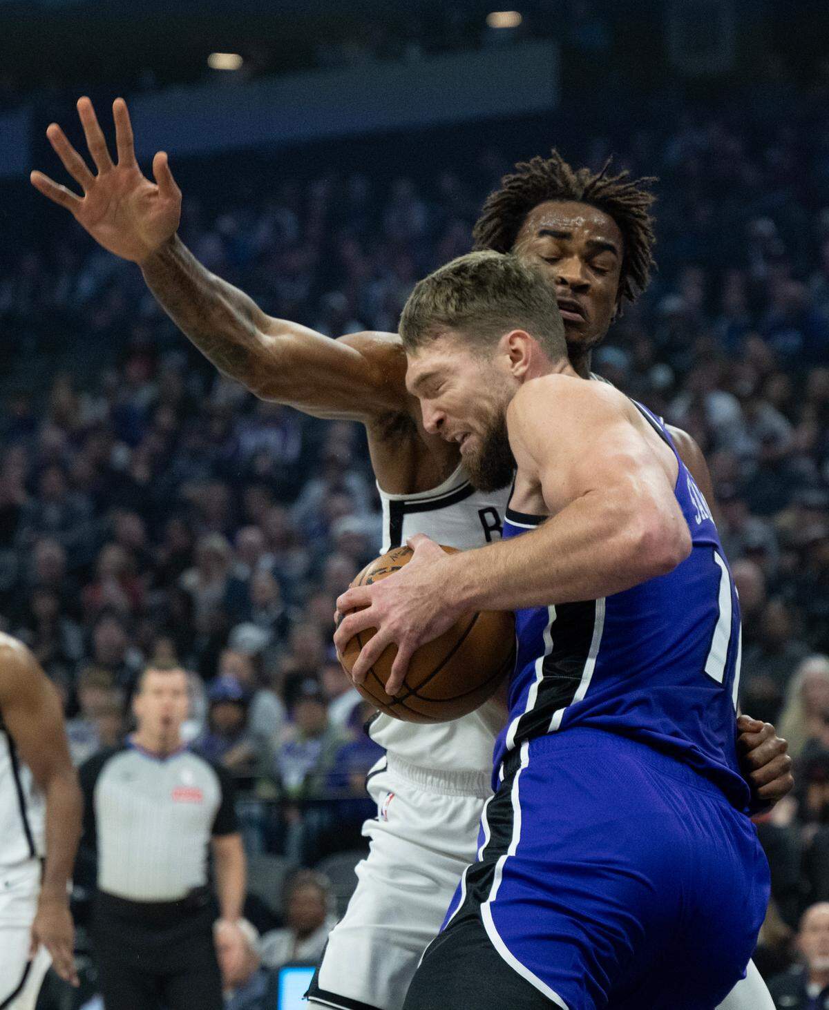 Sacramento Kings center Domantas Sabonis (11) battles Brooklyn Nets center Nic Claxton (33) as he drives to the basket at Golden 1 Center on Sunday.