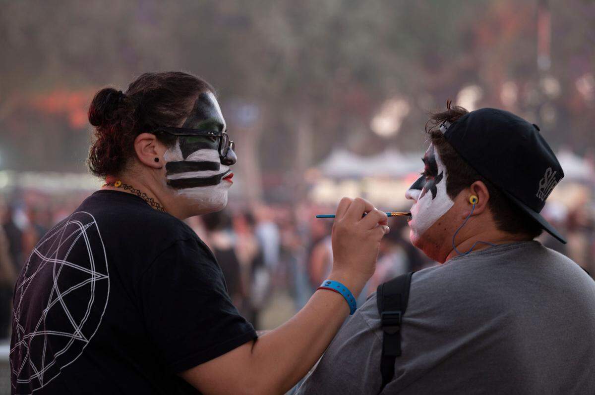 Kiss fans Jovita and Abraham Hernandez, brother and sister from Hesperia, paint their faces to look like band members at the Aftershock Festival on Friday night.