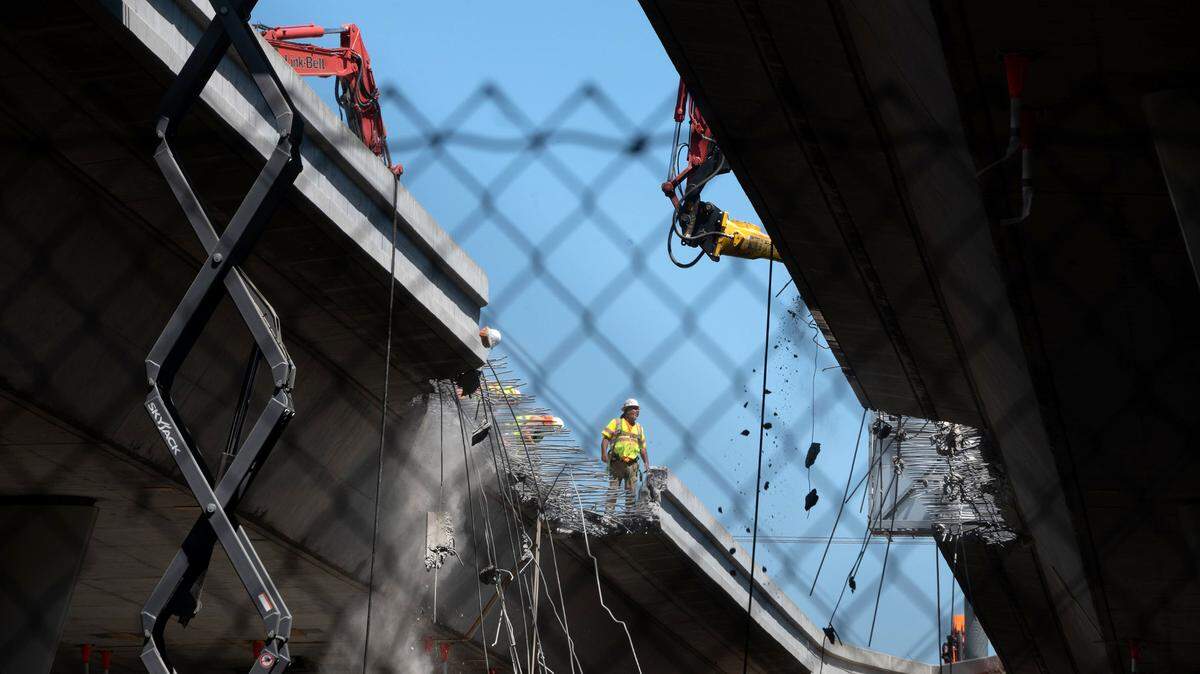 Caltrans workers start to demolish the guiderails between the westbound and eastbound bridges carrying the W-X freeway through Sacramento between 23rd and 24th streets on Tuesday. The $460 million project will fill in the gap between the two structures as it adds carpool lanes to Highway 50 in one the most ambitious freeway reconstructions in the cityís history.