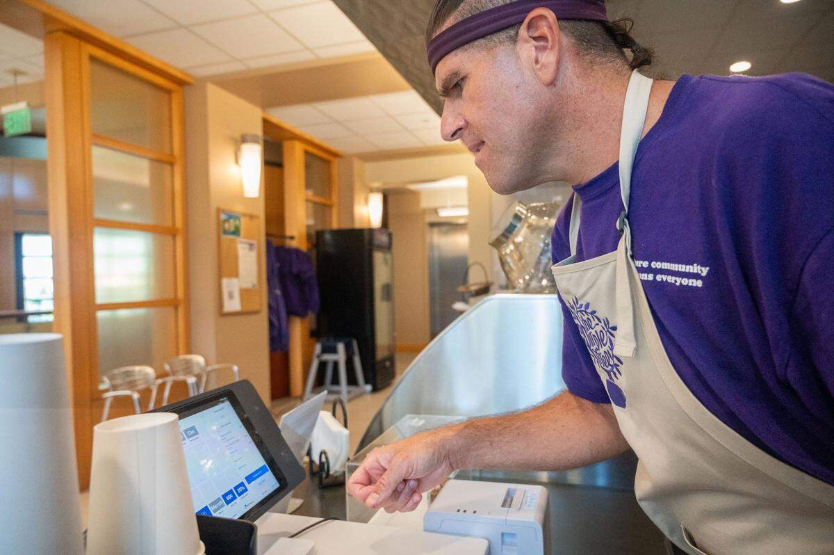 Purple Tree Café employee Tone Martinez rings up a customer’s order on Thursday, June 6, 2024, at the cafe, which is housed inside the MIND Institute at the UC Davis Medical Center in Sacramento. Martinez, who is on the autism spectrum, works up to nine hours a week at the cafe. Many of the cafe’s employees have mental, physical and/or developmental disabilities