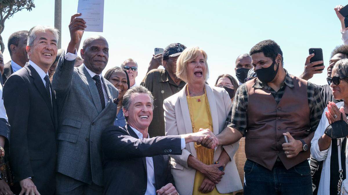 California Gov. Gavin Newsom shakes hands with Anthony Bruce after signing a bill, “Bruce’s Beach Bill”, Thursday, Sept. 30, 2021, in Manhattan Beach, Calif. , that would help clear the way for Los Angeles County to return a piece of Manhattan Beach coastline to the descendants of a Black family who had the land stripped away by the city nearly a century ago.