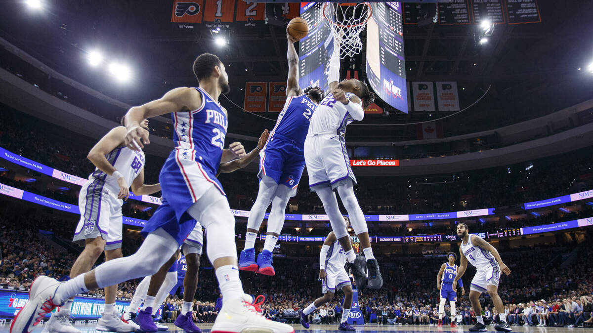 Philadelphia 76ers’ Joel Embiid, center, goes up for the dunk over Sacramento Kings’ Richaun Holmes, right, during the first half of an NBA basketball game, Wednesday, Nov. 27, 2019, in Philadelphia. (AP Photo/Chris Szagola)