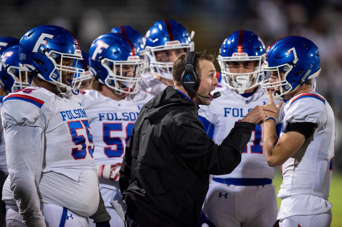 Folsom coach Paul Doherty talks to quarterback Tyler Tremain (7) during a timeout in the first quarter of the CIF Division I regional finals game against De La Salle in Concord on Friday, Dec. 3, 2021. The Bulldogs won 28-27.