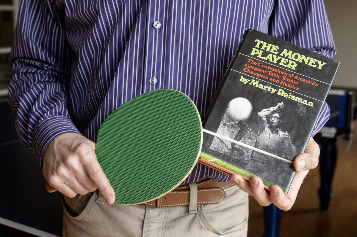 Scott Gordon holds the autobiography of table tennis star Marty Reisman, and the type of paddle Reisman used, on Thursday in Carmichael. 
