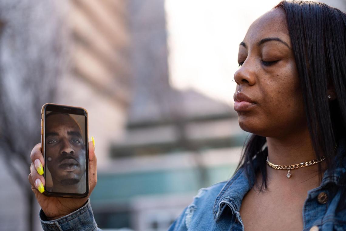 Jael Barnes, of Livermore, holds a photo of her husband, Jamaine Barnes Sr., who is incarcerated behind her at Sacramento Main Jail, on Wednesday, Feb. 10, 2021, in downtown Sacramento. He has been working as an inmate custodian for several weeks without knowing the results from his COVID-19 test. She said the test results are a major concern in addition to his pre-existing physical and mental health issues. She added if the results came back positive, “he’s confined in that cell that’s even scarier.”