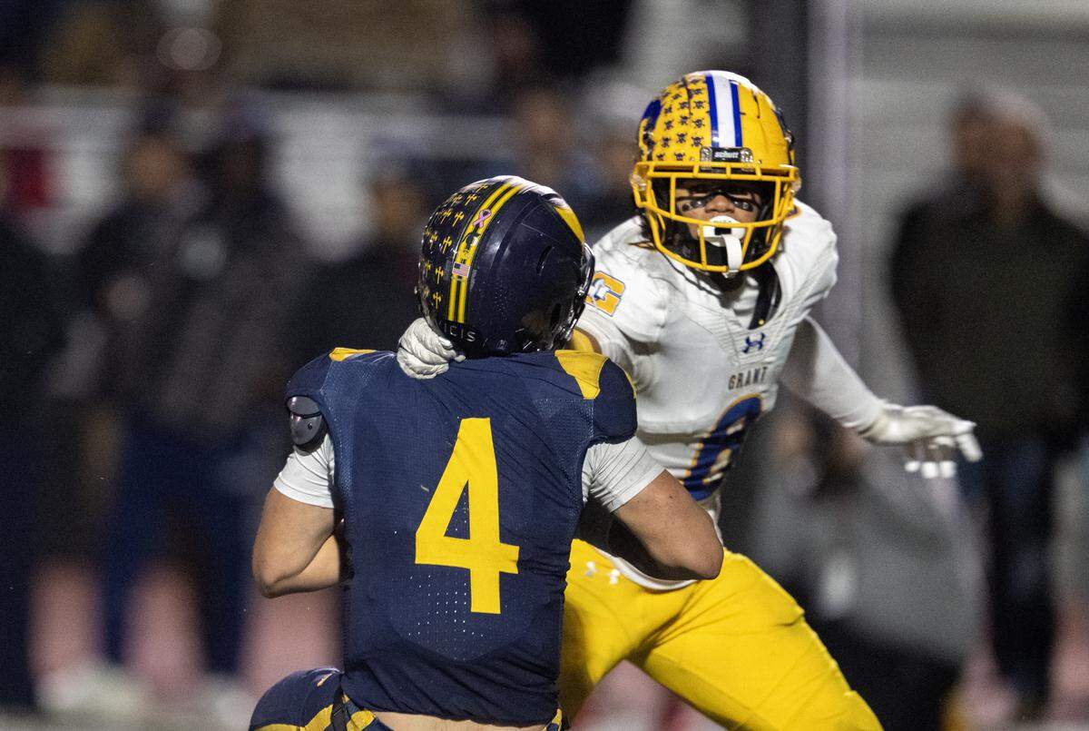 Julian Bruno (6) of the Grant Pacers grabs the jersey of Oak Ridge Trojans quarterback Luke Taber (4) in the second half of the CIF Sac-Joaquin Section Division I semifinal football playoff game held in El Dorado Hills on Friday, Nov. 21, 2025. Bruno was penalized for grabbing Taber’s face mask.