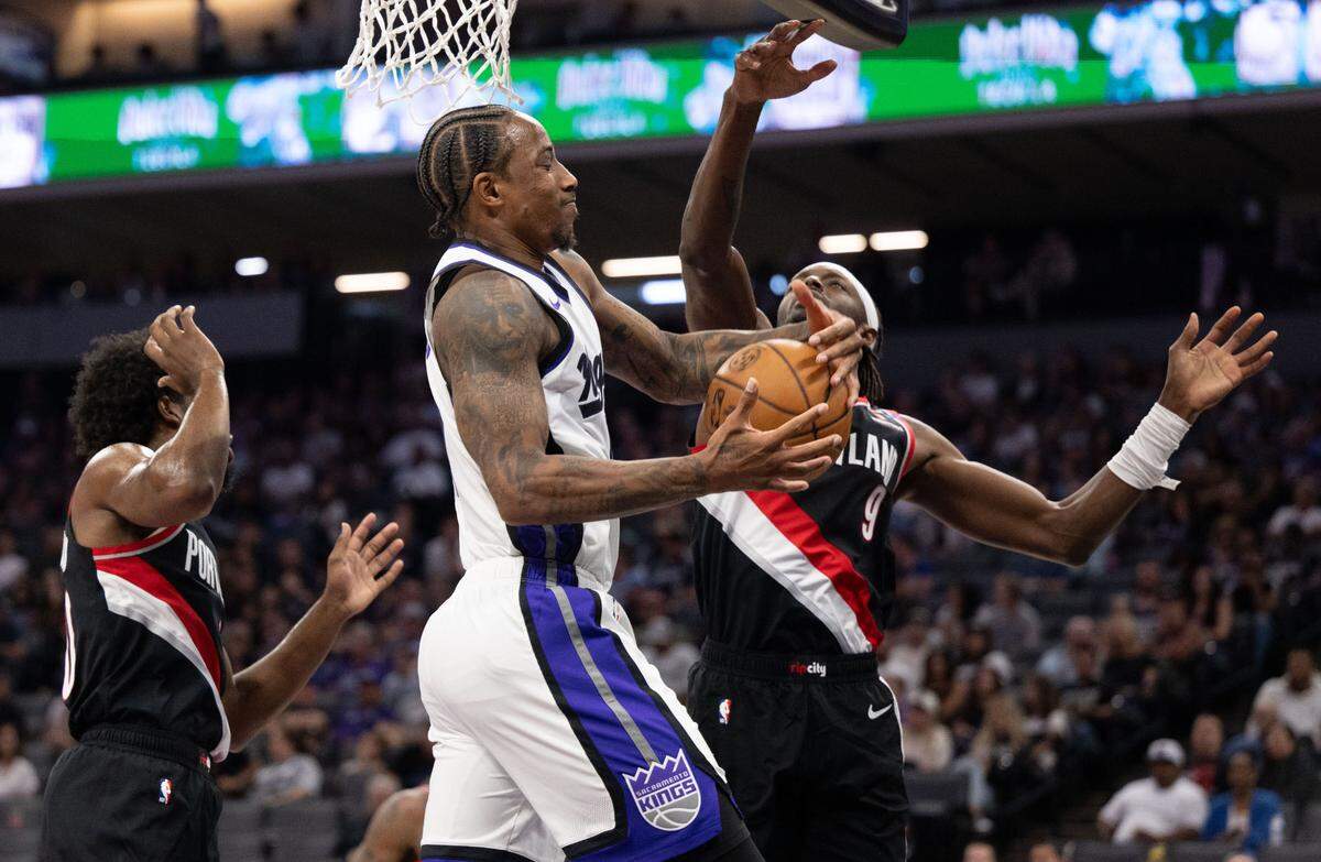 Sacramento Kings forward DeMar DeRozan (10) is fouled by Portland Trail Blazers forward Jerami Grant (9) as he drives to the basket during a preseason NBA game on Oct. 13, 2024 at Golden 1 Center.