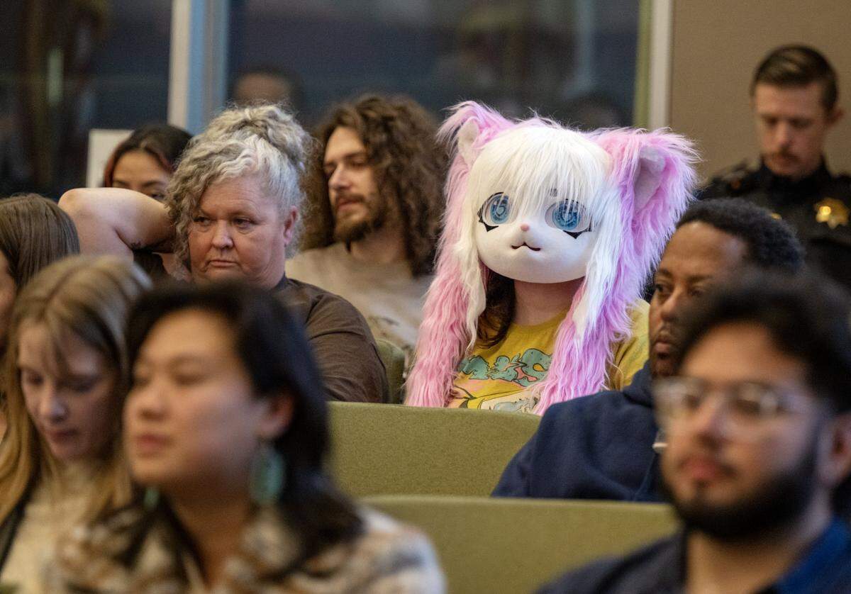 Karissa and her daughter Zoey Boucher listen to speakers during public comment at the Sacramento City Council meeting on Tuesday.