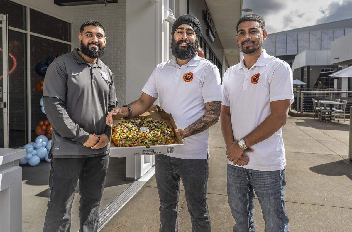 Brandon Boparai, Amrit Singh and Rajpal Shillong, co-owners of Tandoori Pizza in Sacramento's Downtown Commons, display a vegetarian pizza Wednesday during the restaurant's grand opening. 