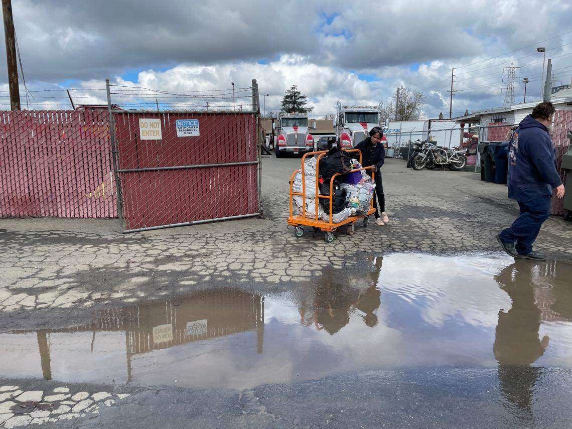 Nicole Casper navigates out of the lot at Chima’s Tow with a large cart of her personal belongings on Wednesday. She lost almost everything she owned when her RV was seized in a Sacramento encampment eviction.