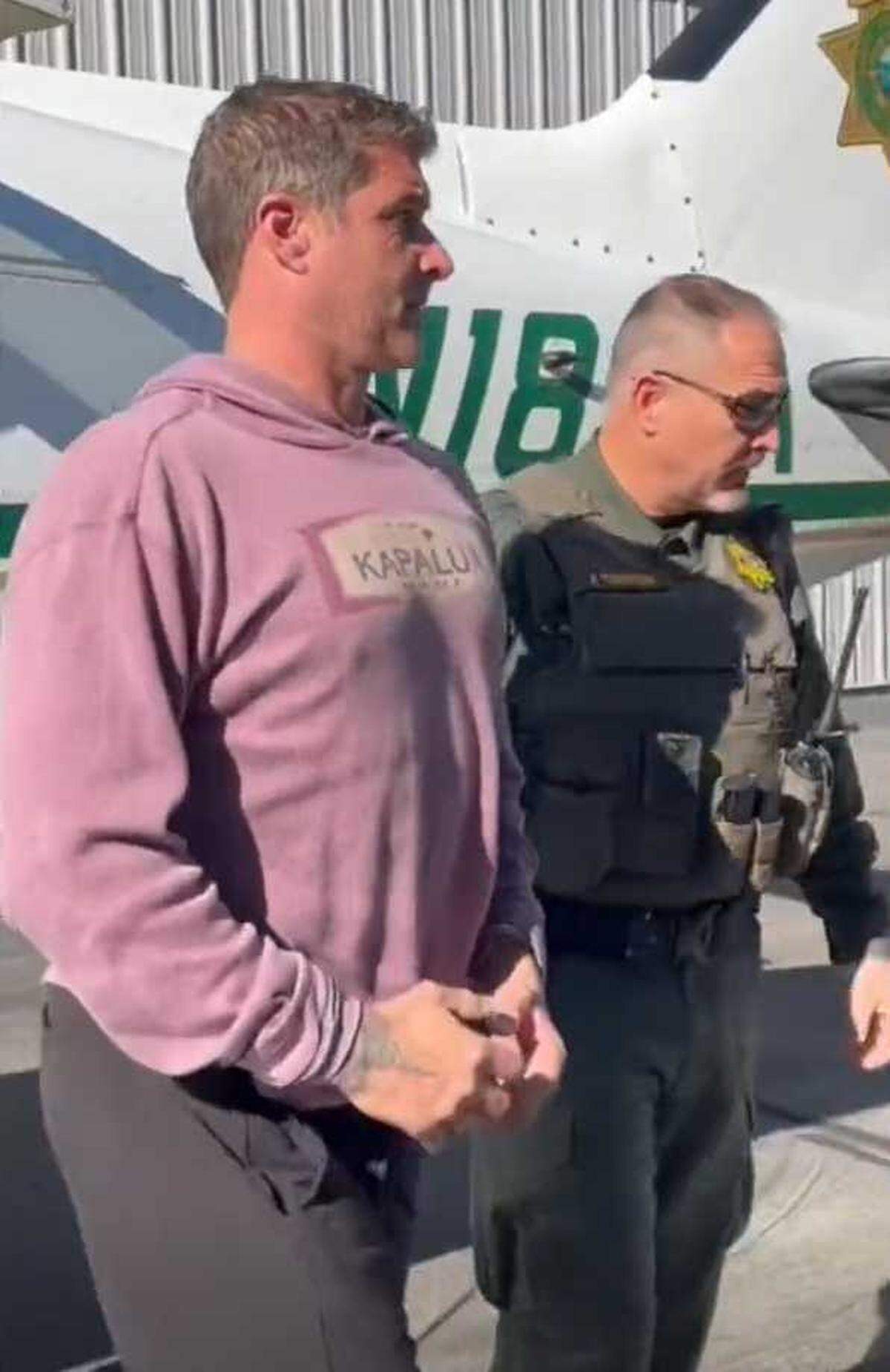 Danny Serafini is led away from a Placer County Sheriff’s Office plane in Auburn on Friday, Oct. 27, 2023. Serafini, a former major league pitcher, is charged in the death of his wife’s father and shooting assault of her mother, who later died.