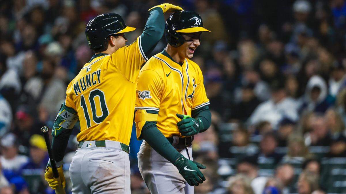 Mar 27, 2025; Seattle, Washington, USA; Athletics first baseman Tyler Soderstrom (21) celebrates with second baseman Max Muncy (10) after hitting a solo-home run against the Seattle Mariners during the eighth inning at T-Mobile Park. Mandatory Credit: Joe Nicholson-Imagn Images