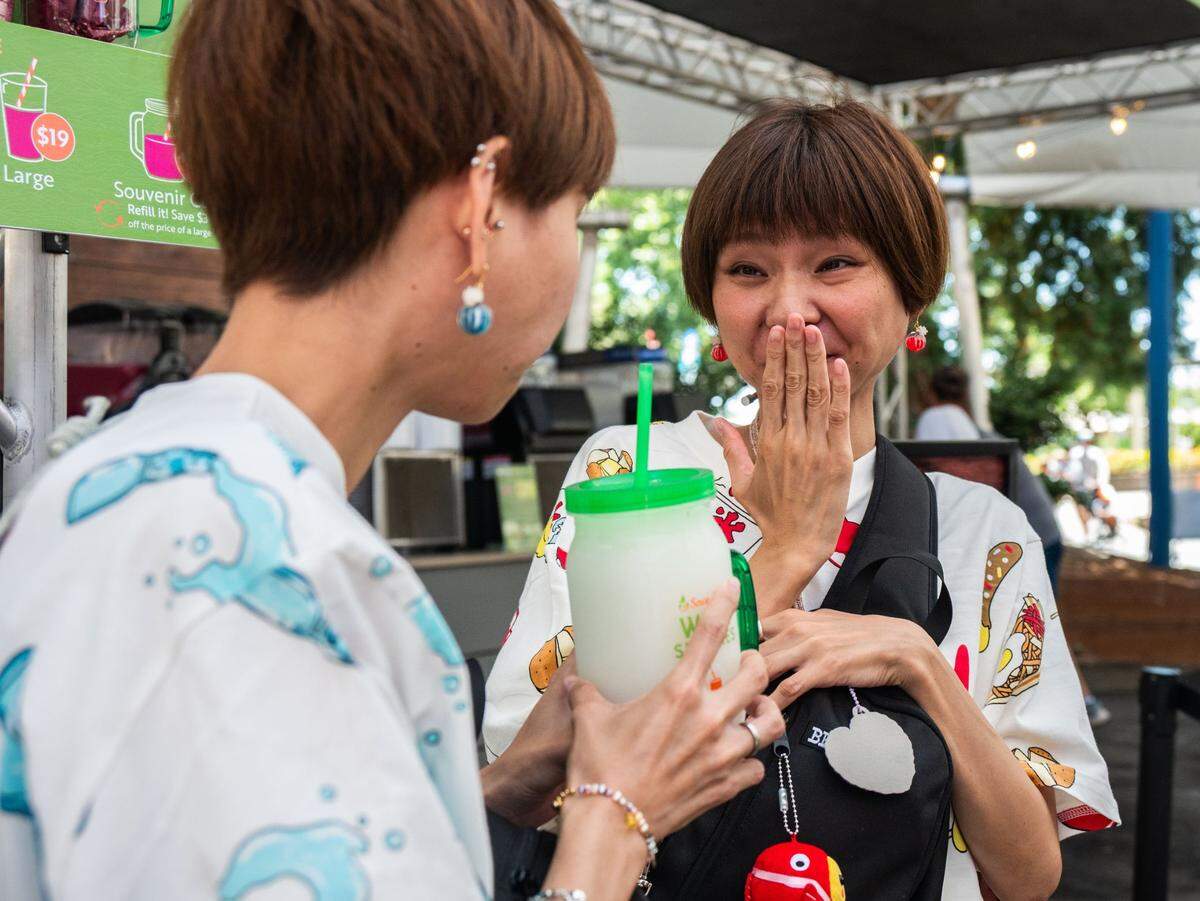 Japanese internet personalities Kako Ono, left, and Ako Ono, right, known as the “hungry twins” on their YourTube channel, try a wine slushie at the California State Fair on Friday.
