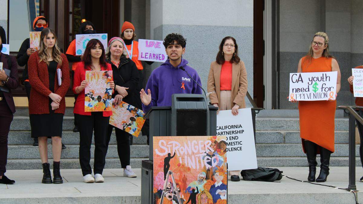 Armaan Sharma, a youth leader from Safe Alternatives to Violent Environments, speaks against domestic and sexual violence in front of the California State Capitol on Tuesday, Feb. 7, 2023. He spoke at “Orange Day of Action,” a rally event hosted by the California Partnership to End Domestic Violence.