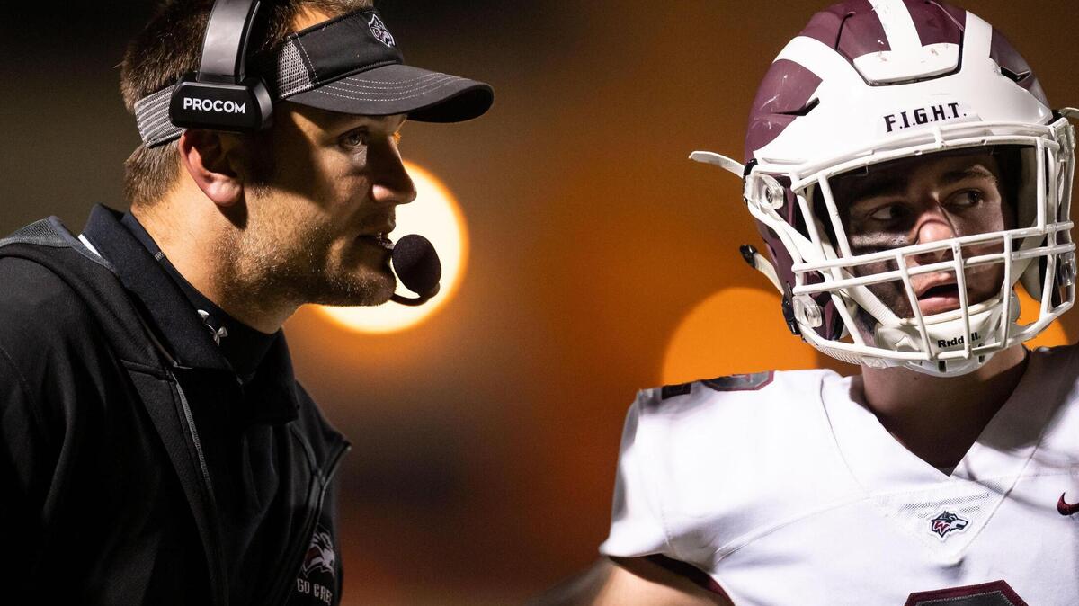 Woodcreek High School Timberwolves head coach Bradley Hunkins coordinates with quarterback Garrett Krupp against Monterey Trail in a 2021 playoff game. Hunkins is one of several Sacramento-area coaches resigning to spend more time with family.