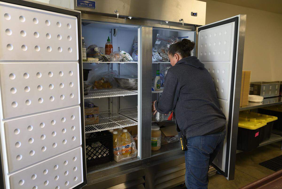 Volunteers of America staff member Jenna Winn places food in a kitchen refrigerator at the VOA’s X-Street Navigation Center on Wednesday, Dec. 1, in Sacramento. The X Street Navigation Center is asking Book of Dreams for donations to buy a new refrigerator for guests to store their own food items.