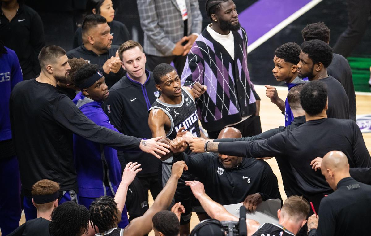 Sacramento Kings guard De’Aaron Fox (5), center, puts his hand into the huddle at the end of a timeout during the first half of Game 1 of the first-round NBA basketball playoff series at Golden 1 Center on Saturday, April 15, 2023.