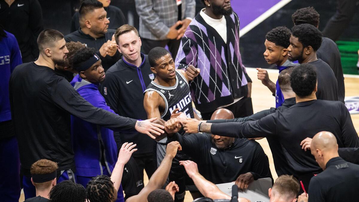 Sacramento Kings guard De’Aaron Fox (5), center, puts his hand into the huddle at the end of a timeout during the first half of Game 1 of the first-round NBA basketball playoff series at Golden 1 Center on Saturday, April 15, 2023.