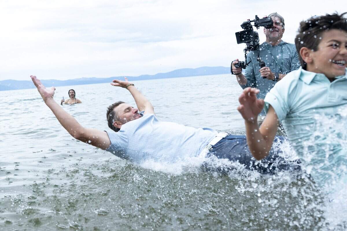 Former professional tennis player Mardy Fish jumps in Lake Tahoe with his son Beckett after winning the American Century Golf Tournament in Stateline, Nev. on Sunday.