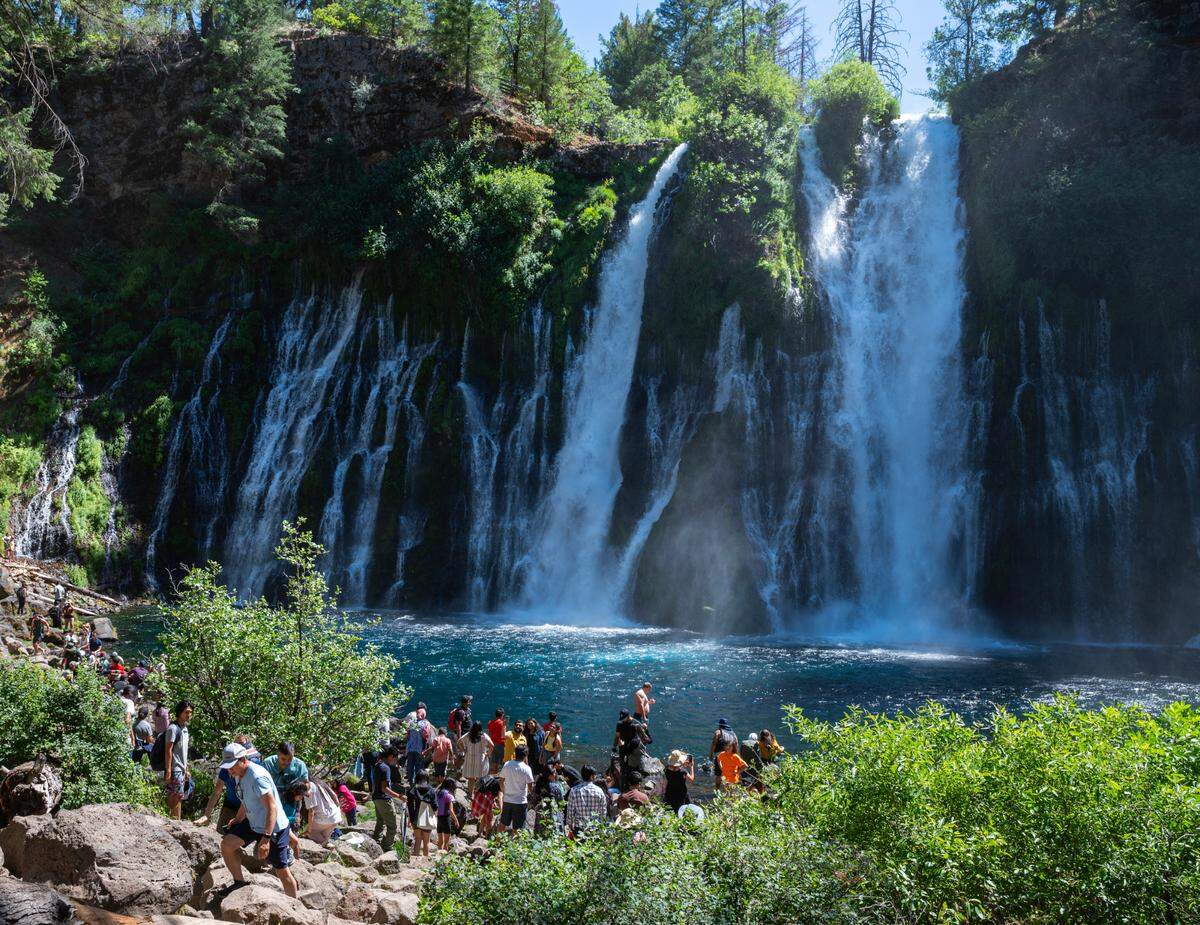 Crowds enjoy Burney Falls, the picturesque waterfall in Shasta County, in July 2022. It now requires a day-use reservation for weekends and holidays during the busy season.