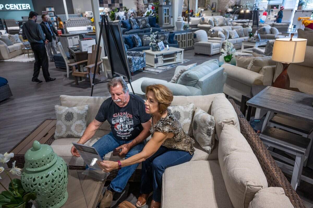 Mike and Dianne Merrit, of Cameron Park, look at the prices of an outdoor furniture set during the grand opening of Bob’s Discount Furniture in Folsom on Friday.