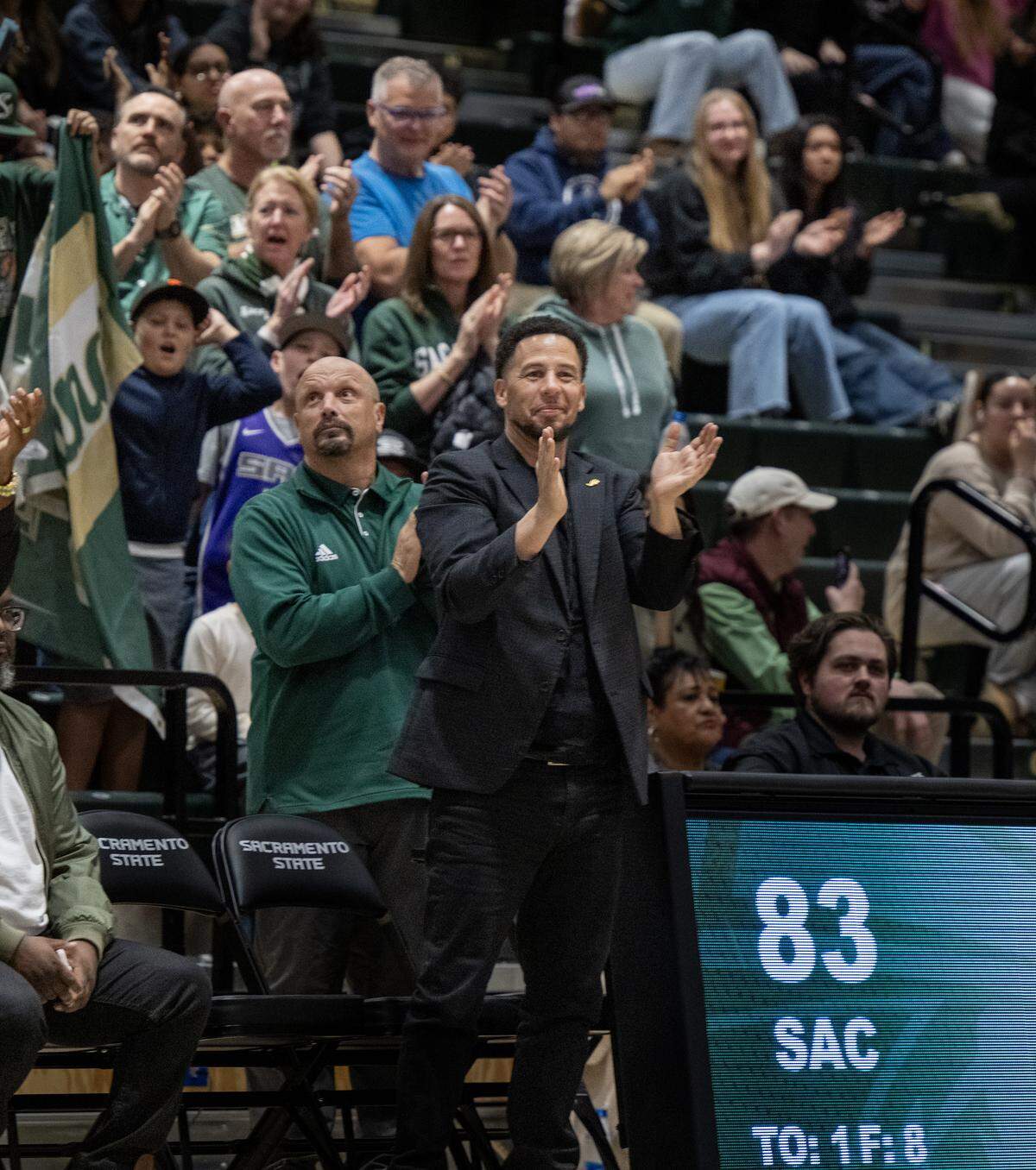 Sacramento State President Luke Wood, center, and athletic director Mark Orr celebrate the men’s basketball team’s victory over the Northern Arizona Lumberjacks on Thursday in Sacramento. 