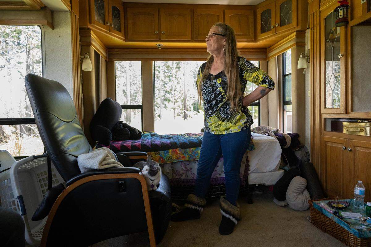 Jenny Magidson, 67, stands on May 1 in a trailer she has lived in since the 2021 Caldor Fire. Her son, Tobe Magidson, bought the property the trailer is on after the fire destroyed their homes in another part of Grizzly Flats.