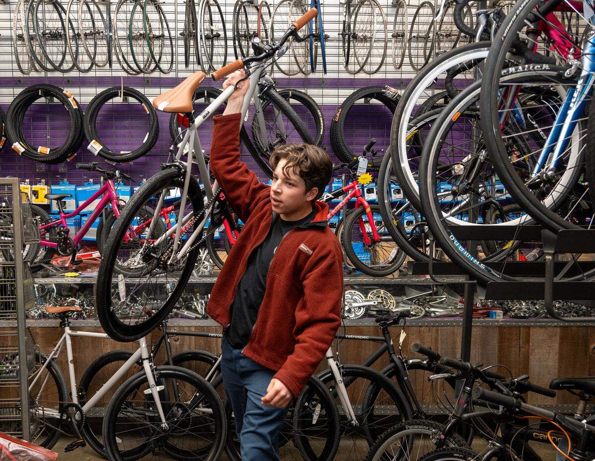 Winston Holtkamp, 17, of Boys 4 Bikes carries one of the bikes they purchased from Sutterville Bicycle Company on Dec. 8, 2023.
