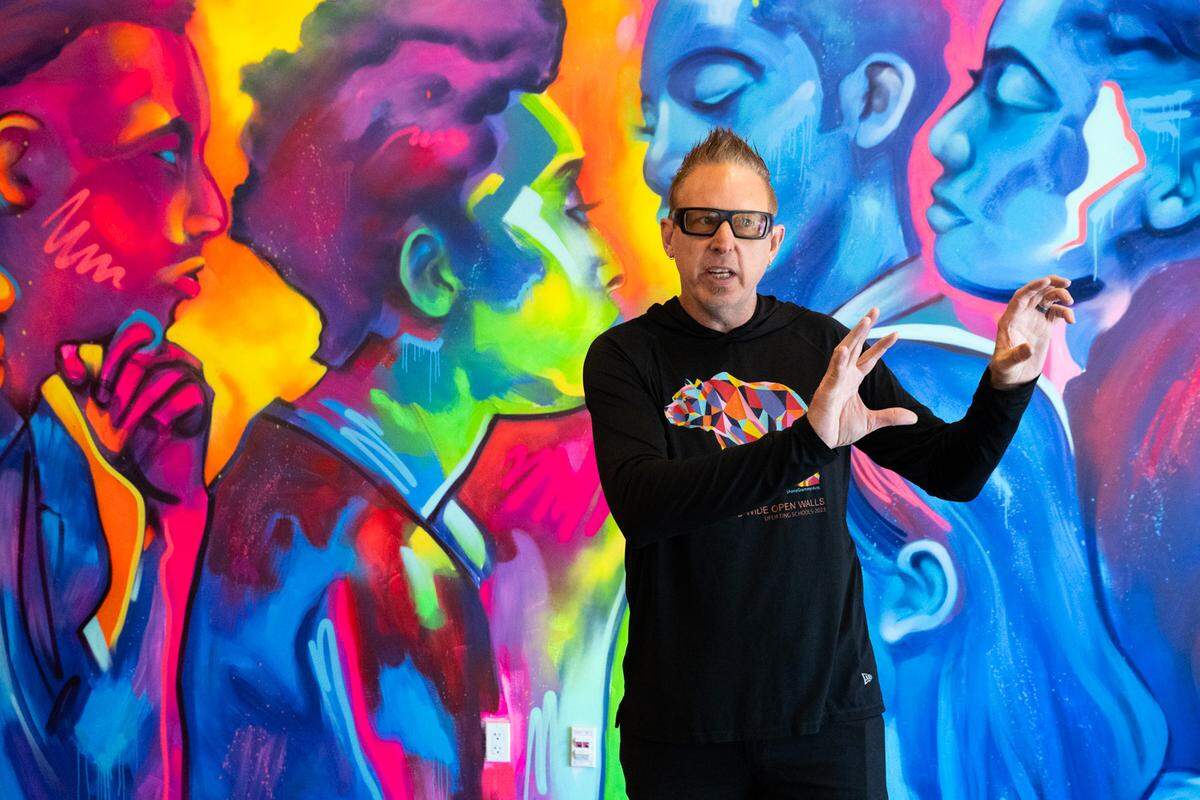 Artist Shane Grammer describes the inspiration for “Unity in Motion,” one of two murals he created for Aggie Square in Sacramento, on Friday.