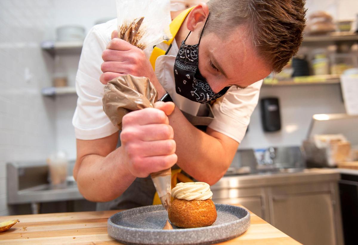 Ramon Perez, executive pastry chef at The 7th Street Standard, prepares a cream puff with hazelnut praline ice cream, caramel chantilly and chocolate.
