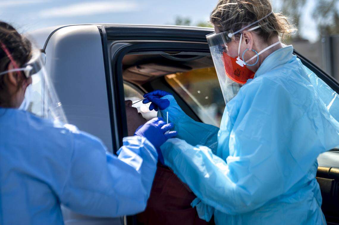 Bennett, right, uses a nasopharyngeal swab as certified medical assistant Maria Zepeda, left, holds a throat swab.