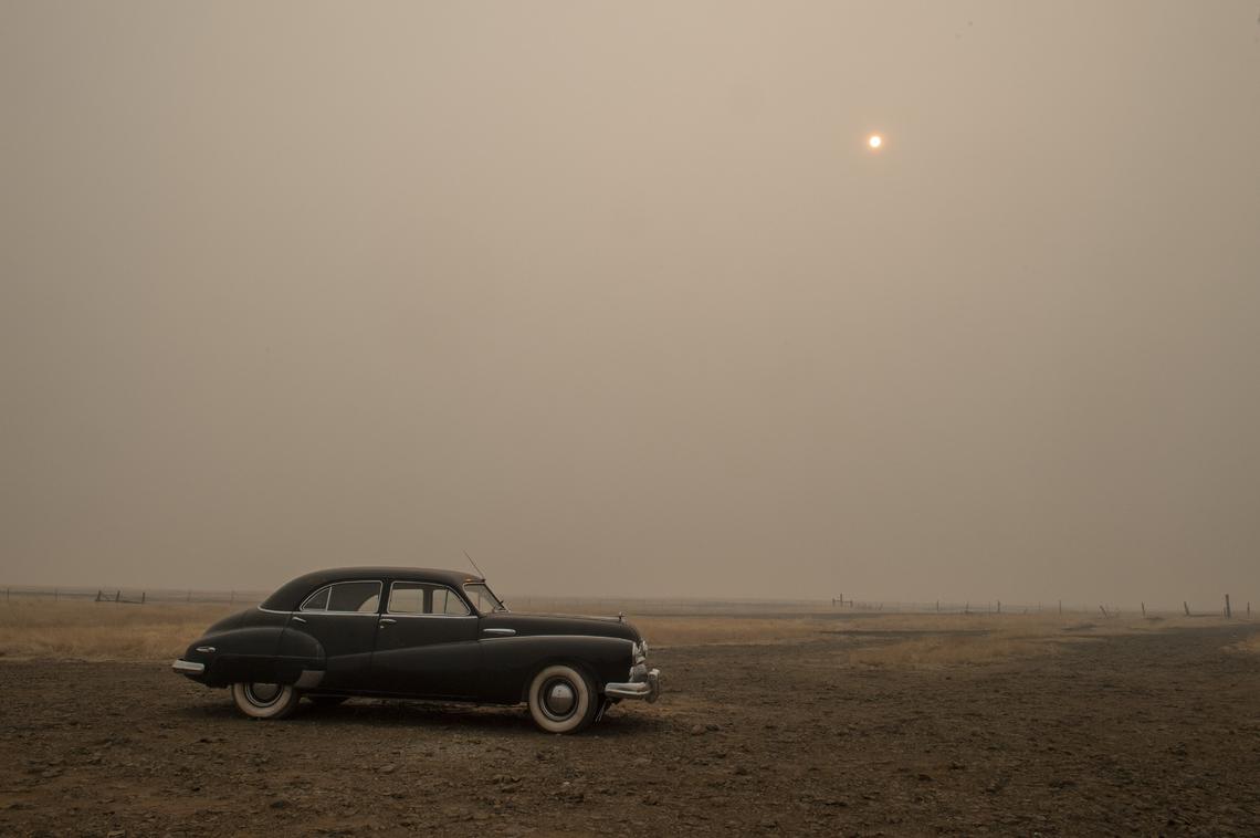 A classic car escaped the flames of the Camp Fire in a desolate scene with an orange sun peaking through the smoke on Thursday Nov. 15, 2018 in Paradise.