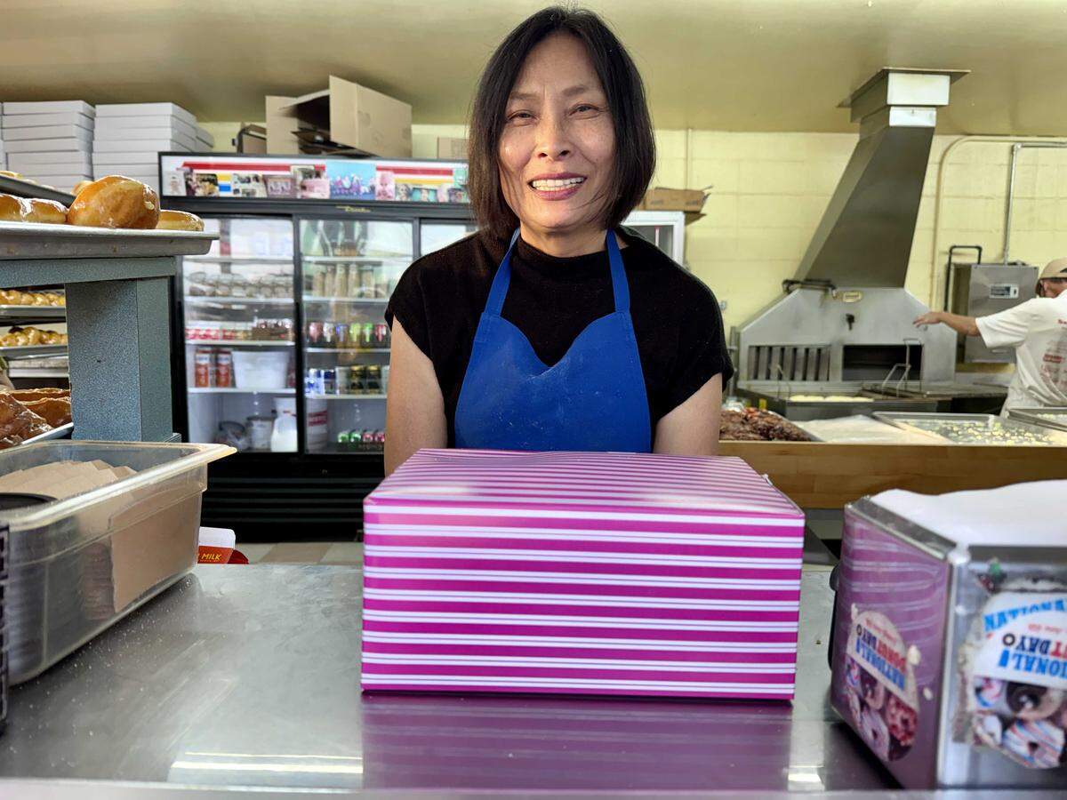 Linda Lee of Marie's Donuts sells a half-dozen in one of their signature pink boxes on Jan. 27. There is speculation that Marie's Donuts is the oldest doughnut shop in Sacramento.