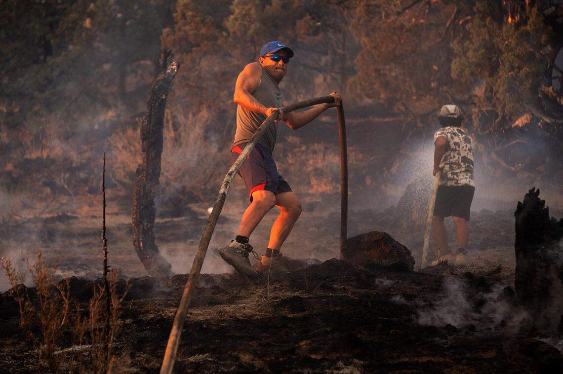 Hmong residents brought in their own water tank truck to help put out the hot sports at a burning marijuana farm during the Lava Fire on Tuesday, June 29, 2021, outside of Weed in Siskiyou County. Siskiyou County sheriff said officers shot and killed a man after he fired a gun at them near a large complex of cannabis farms threatened by the Lava Fire.
