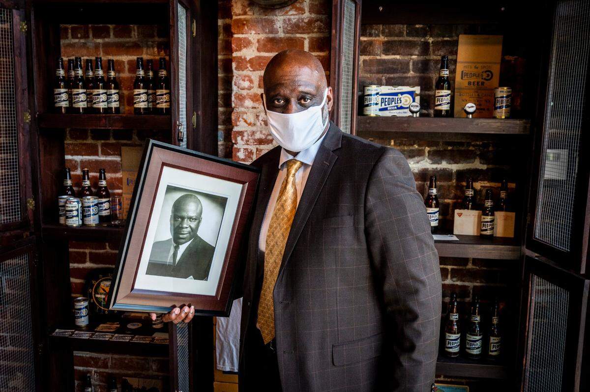 Ted Mack II holds a picture of his father Ted Mack Sr. at Oak Park Brewing on Thursday, Aug. 27, 2020. Oak Park brewing bought the rights to the 1970s recipe that his father created and began canning Oak Park’s People’s Beer. The recipe is from America’s first Black breweries located in Oshkosh, Wisconsin.