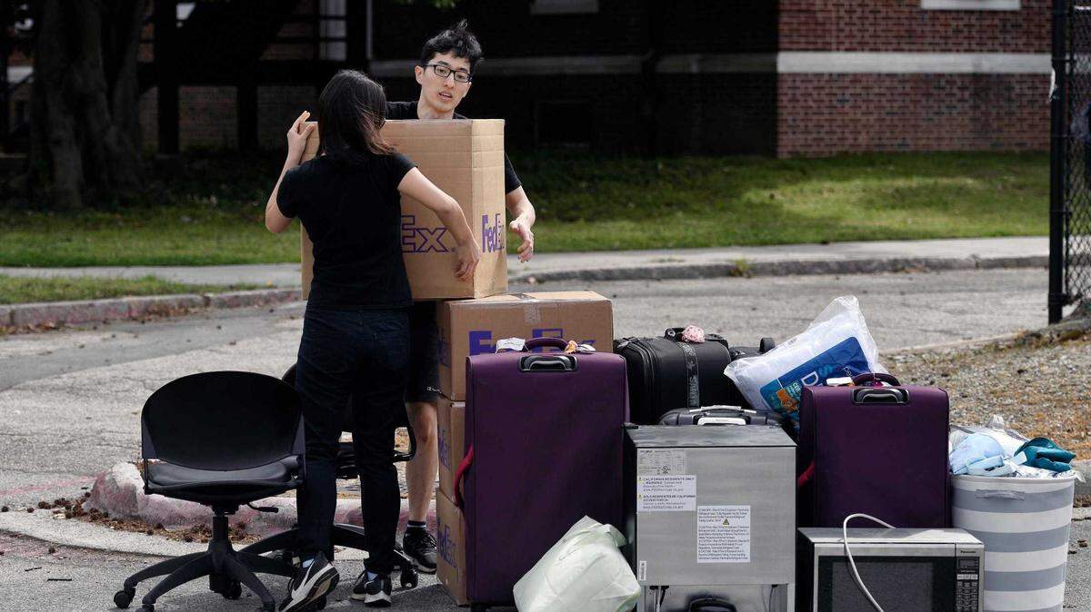 Duke freshman Feng Cong from Singapore and Cassie Lu from Thailand carry a box to a pile of their belongings as they move out of dorms at Duke University on Sunday, March 15, 2020. Cong will be returning home to Singapore and Lu to Thailand since students are being asked to move out and complete classes online for the rest of the semester due to the coronavirus.