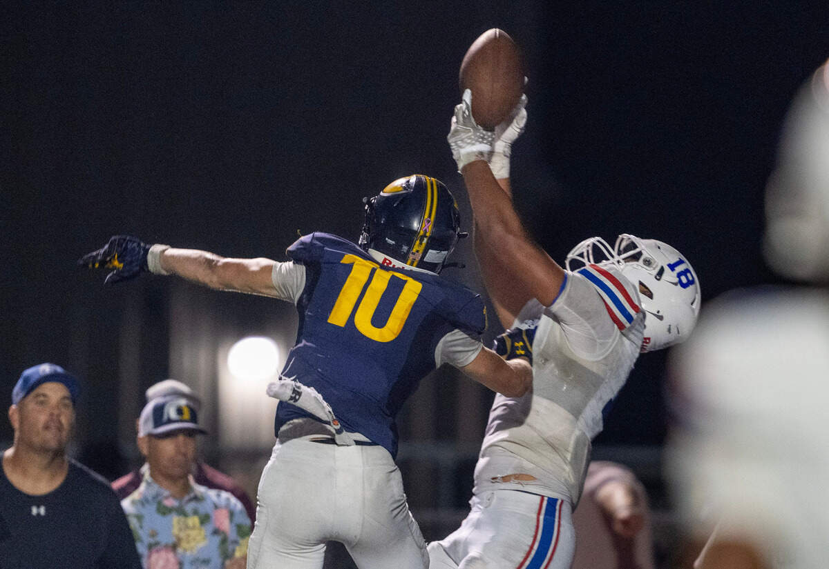 The Folsom Bulldogs’ Taniela Tupou (18) catches a touchdown pass over Oak Ridge Trojans defender Jasen Womack (10) In the first half on Friday, Oct. 4, 2024 in El Dorado Hills.