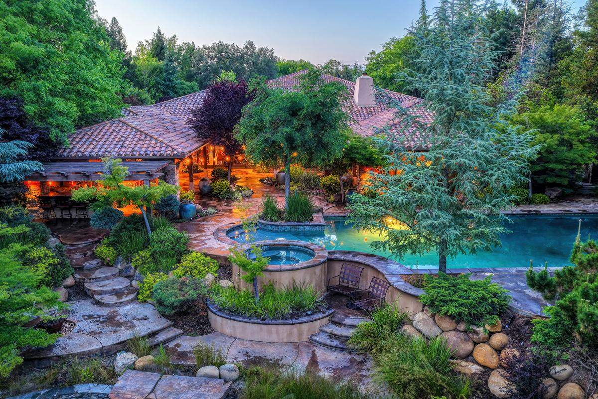 A sprawling pool, outdoor kitchen and garden beds anchor the backyard, designed for everything from quiet afternoons to large gatherings in a setting that feels like a private resort.
